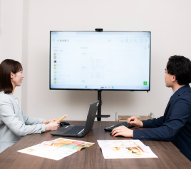 写真：モニターを見ながら話をしている2人の職員